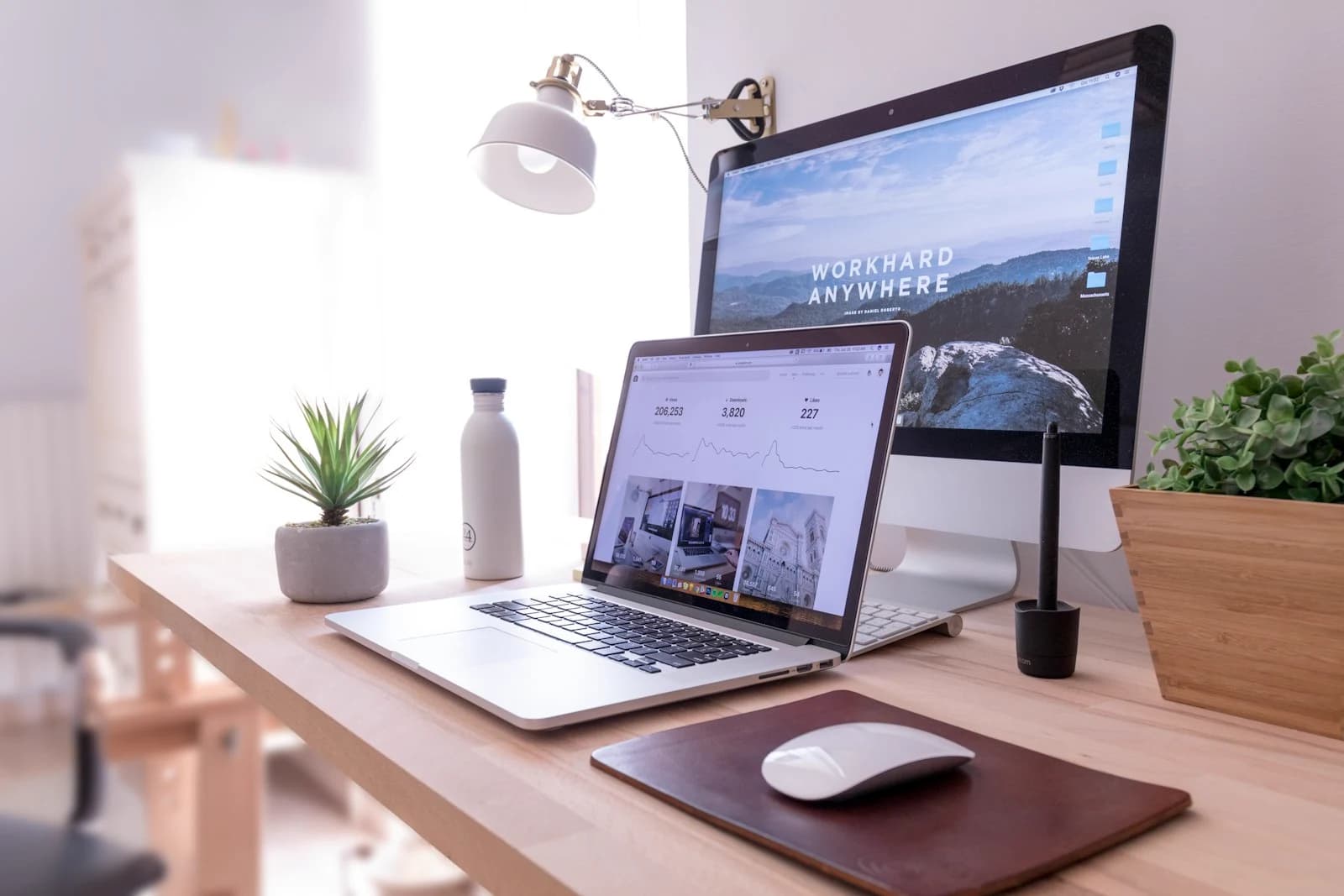 Modern web design workspace — a website hero rendered on a desktop monitor alongside live analytics on a laptop, the day-to-day of designing and tuning CT small-business websites.